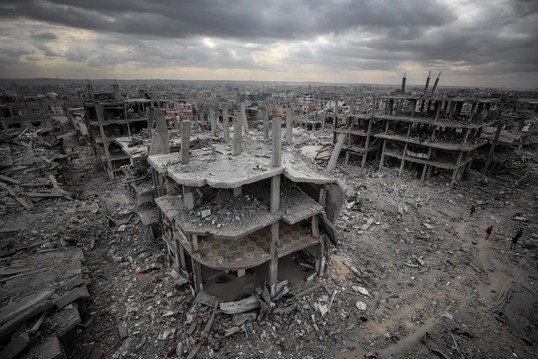 Aerial view of Israel's destruction of Gaza City's Sabra neighborhood after the October 2025 ceasefire deal was signed. Features a destroyed multi-level building, surrounded by rubble of other destroyed buildings.