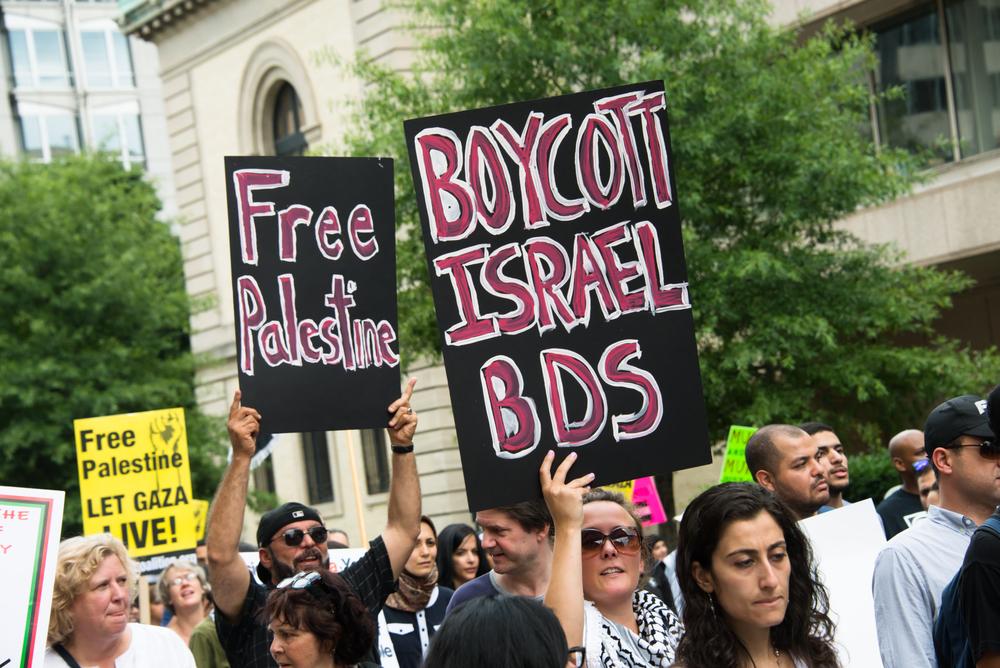 Protestors carry signs that say "Boycott Israel: BDS," "Free Palestine," and "Free Palestine: Let Gaza Live" at a demonstration against Israel's 2014 war on Gaza, also known as Operation Protective Edge.