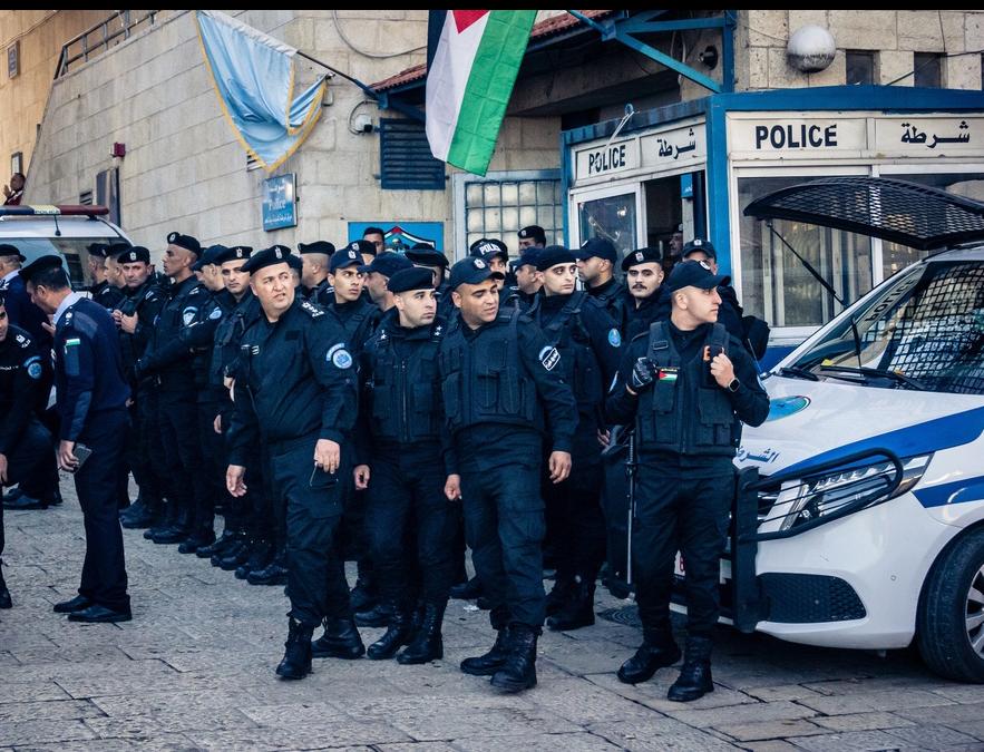 A large crowd of Palestinian Authority (PA) security forces stand outside of a police station in Bethlehem in the West Bank.