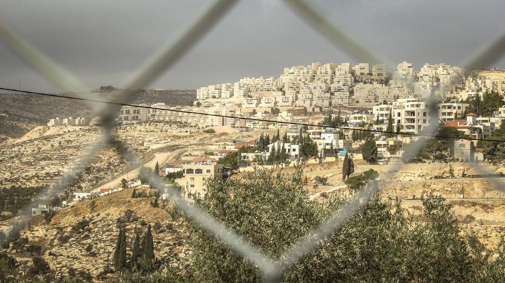 Image behind a fence showing the Israeli settlement of Har Homa in southern East Jerusalem, built on land seized from the Palestinian villages of Umm Tuba and Beit Sahour.
