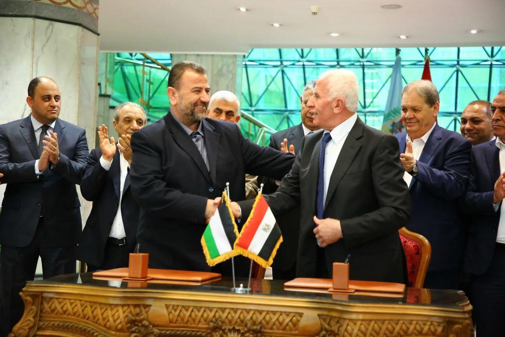 Hamas leader Saleh Al-Arouri and Fatah leader Azzam Ahmad shake hands after the signing of a national reconciliation agreement in Cairo. They are joined by other leaders from the respective factions, including Yahya Sinwar and Hussein Al-Sheikh, and chief of the Egyptian General Intelligence Directorate Khaled Fawzy.