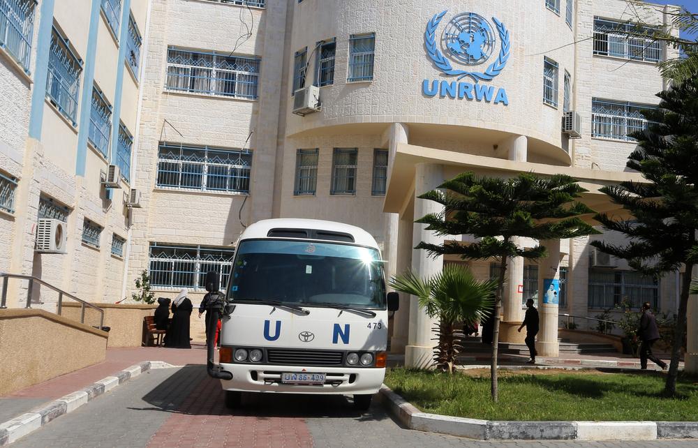 Exterior view of an UNRWA facility, with a United Nations (UN) van parked outside of the building.
