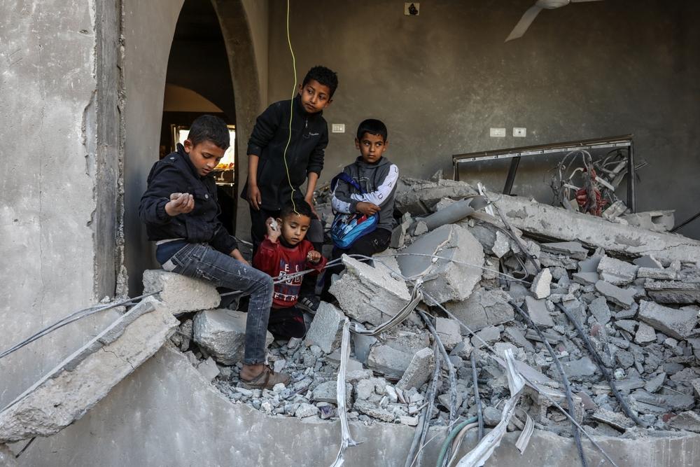 Palestinian children stand on the rubble of their home in Khan Yunis, Gaza.