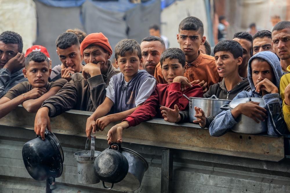 Palestinians await food assistance in Mawasi Khan Yunis due to Israel's policy of forced starvation during its genocide in Gaza.