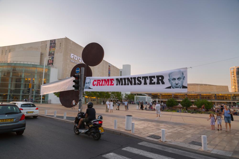 A banner in Tel Aviv with Netanyahu's image reads "CRIME MINISTER" in English. 2018.