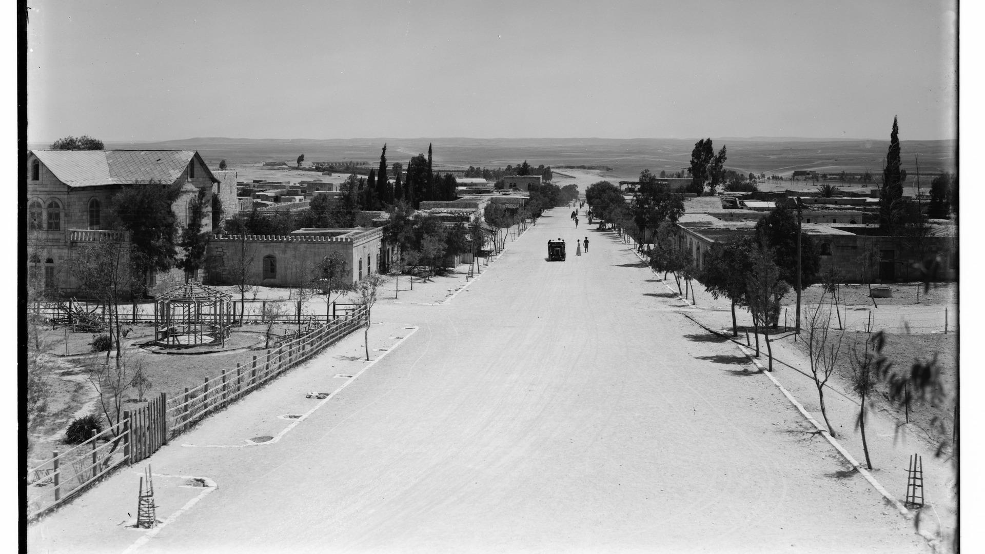 View of Beersheba's main road, with homes and large buildings in view.