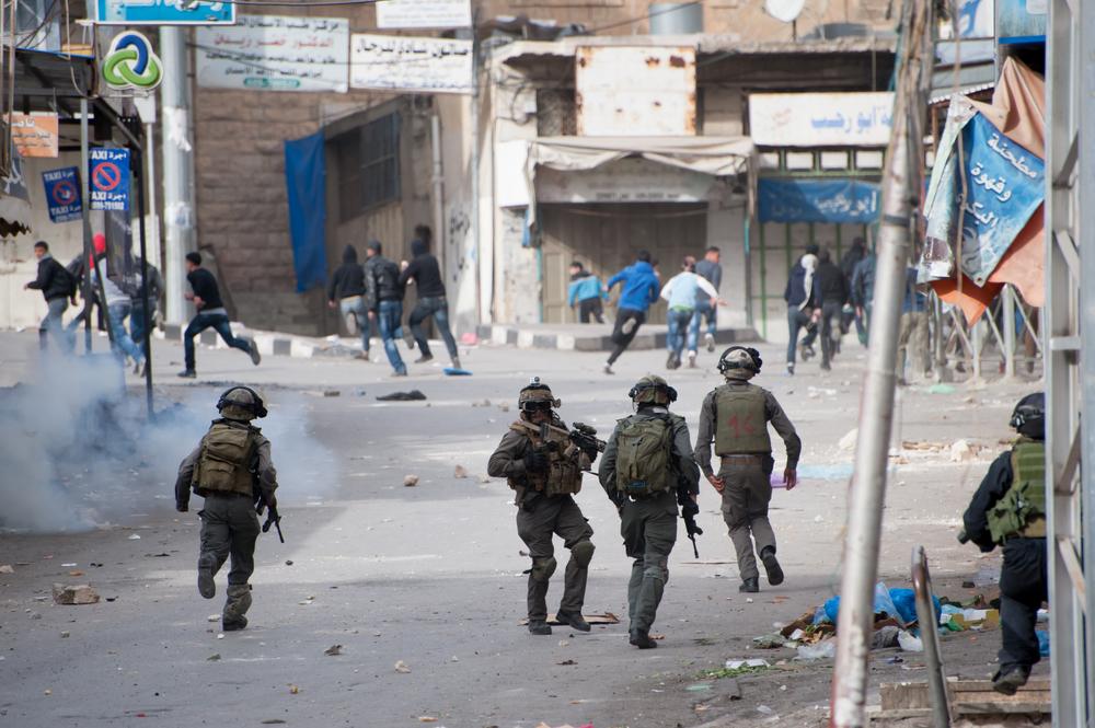 Israeli soldiers chase Palestinians during a protest against the occupation in Hebron.