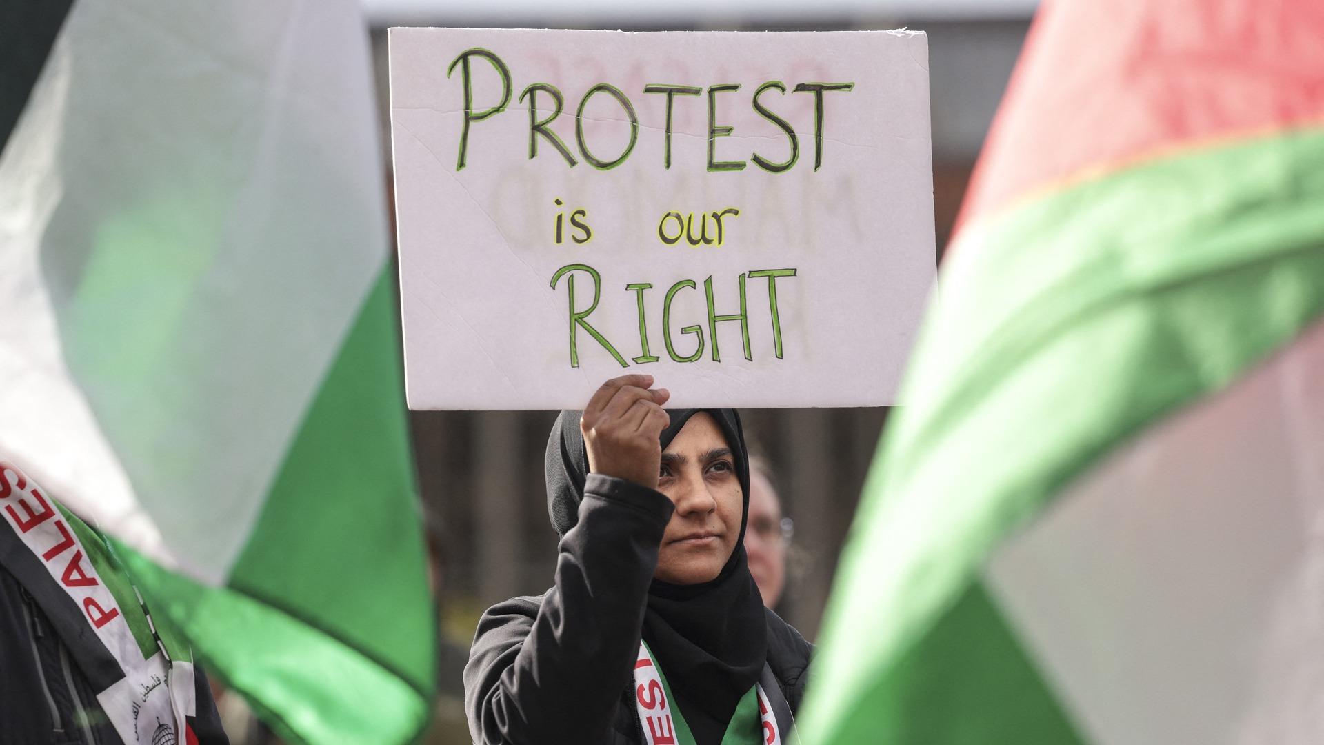 A woman holds up a sign that reads "protest is our right."