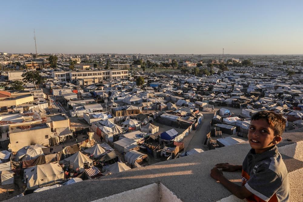 A child stands on a roof overlooking the displacement tents in the crowded Mawasi area of Khan Yunis.