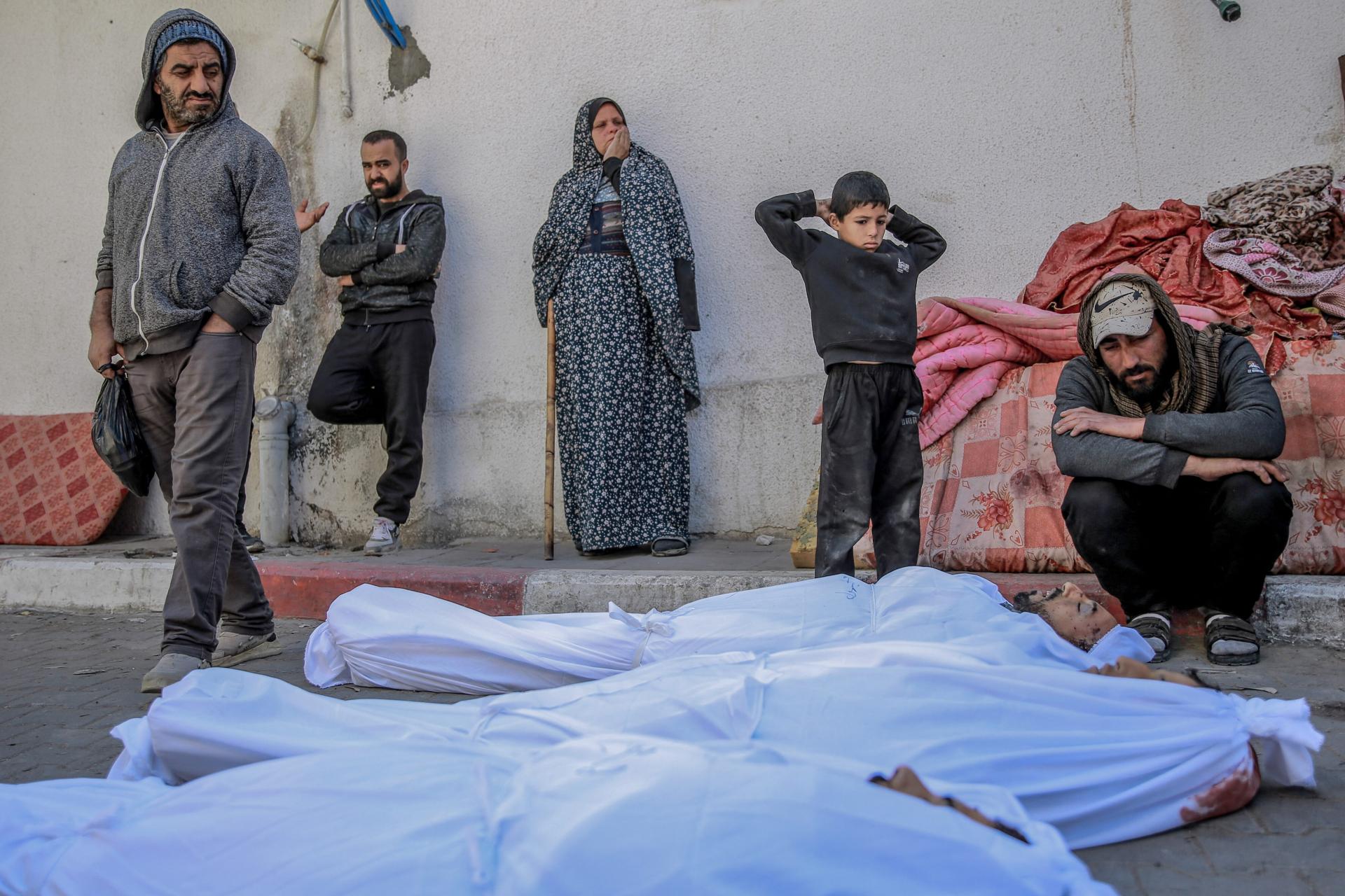 Palestinians mourn the loss of three victims of Israel's Flour Massacre, as they are wrapped in burial shrouds on the grounds of Gaza's Al-Shifa Hospital.