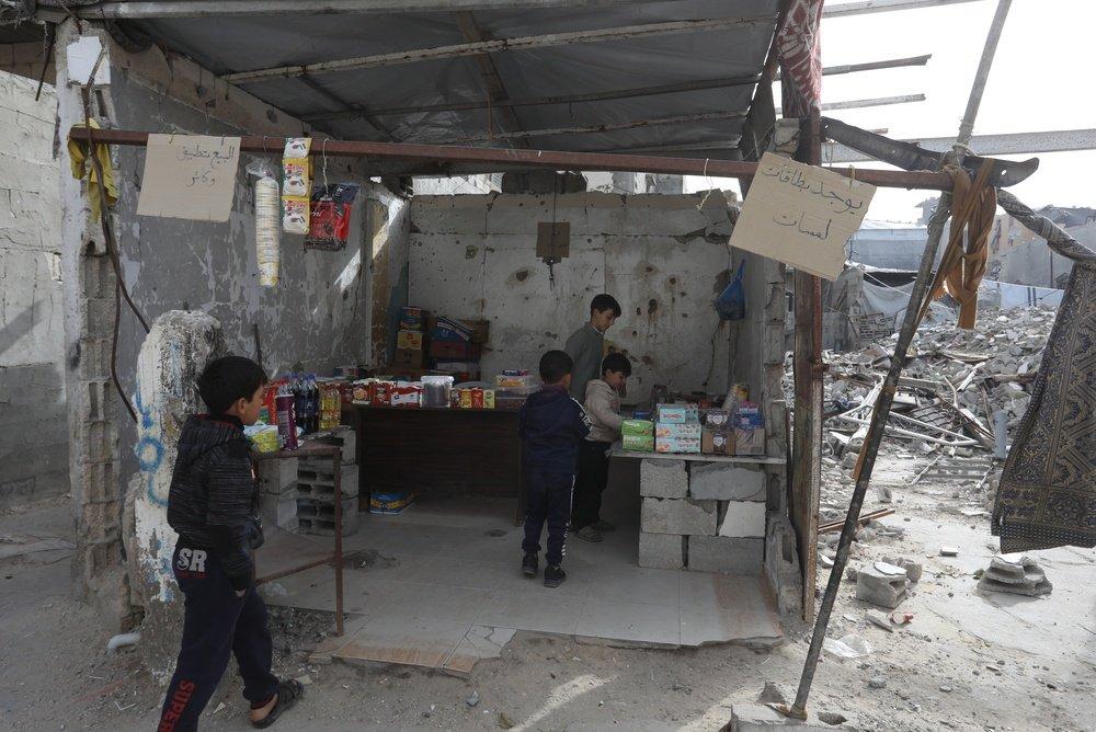 Palestinian children, many of whom suffer from malnutrition, sell goods at a market to help support their families.