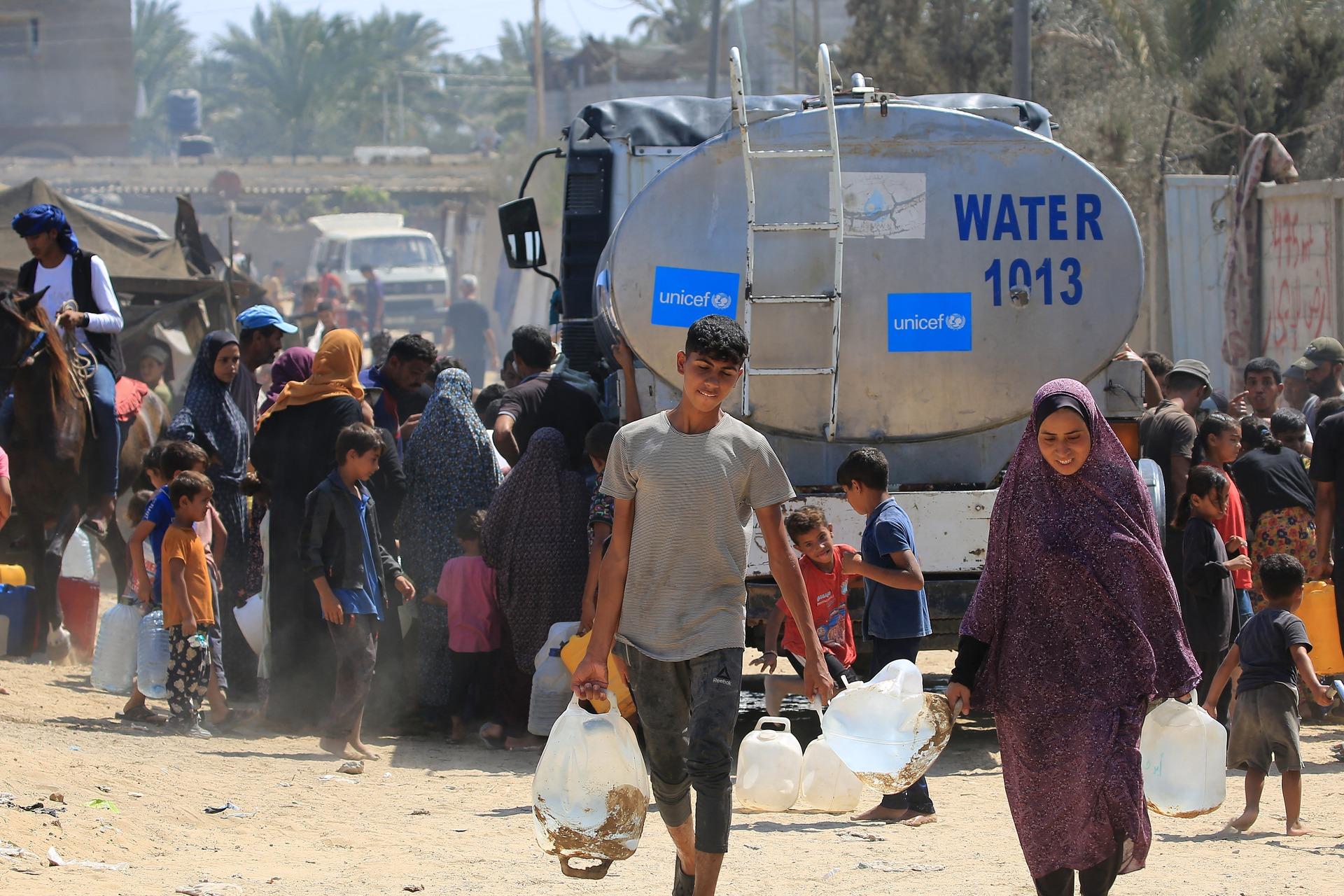 Palestinians collect water provided by UNICEF in Deir al-Balah, Gaza Strip in 2024.