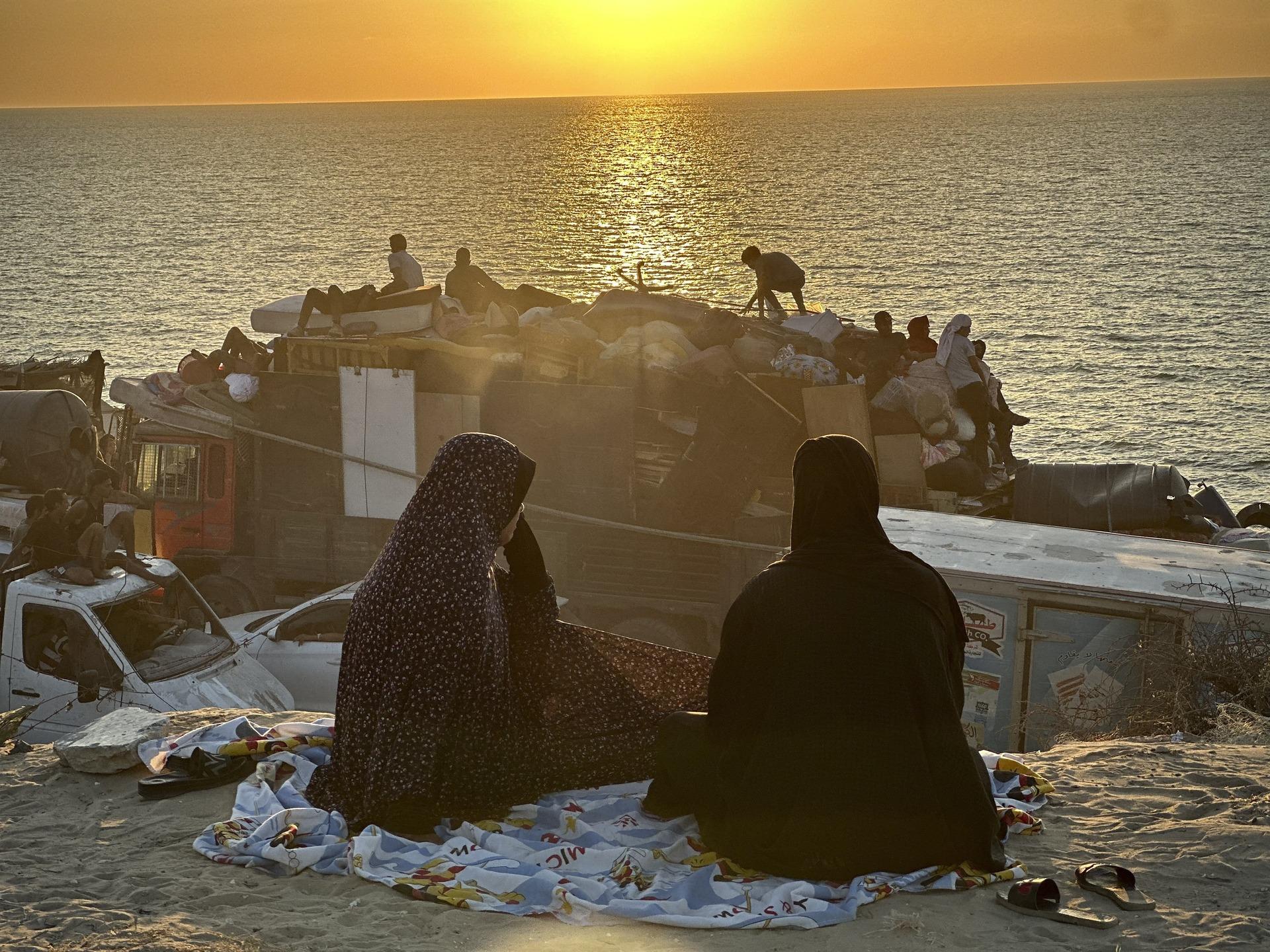 Palestinian women look on at the sunset over the Mediterranean Sea at a beach in Gaza. September 18, 2025.