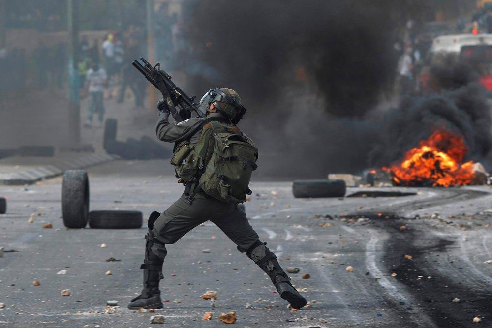 An Israeli soldier shoots at Palestinians in the occupied West Bank. May 15, 2021.