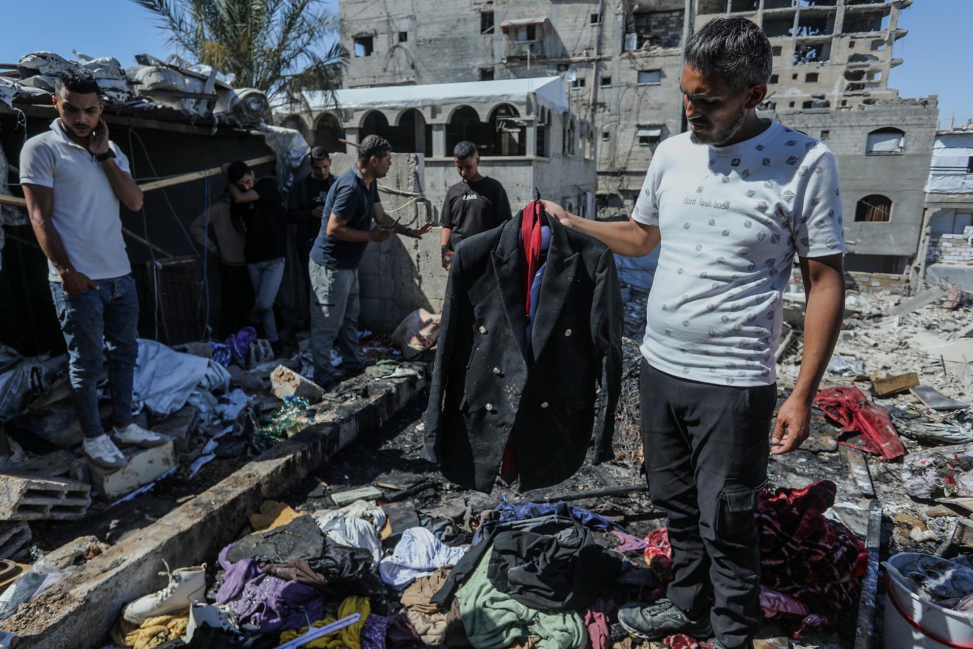 A man carries the suit of Muhannad Othman Farwana, a groom, amid the rubble after an Israeli airstrike on Khan Yunis. Farawna, the groom, was killed in the Israeli airstrike just hours before his wedding was set to take place. June 9, 2026.