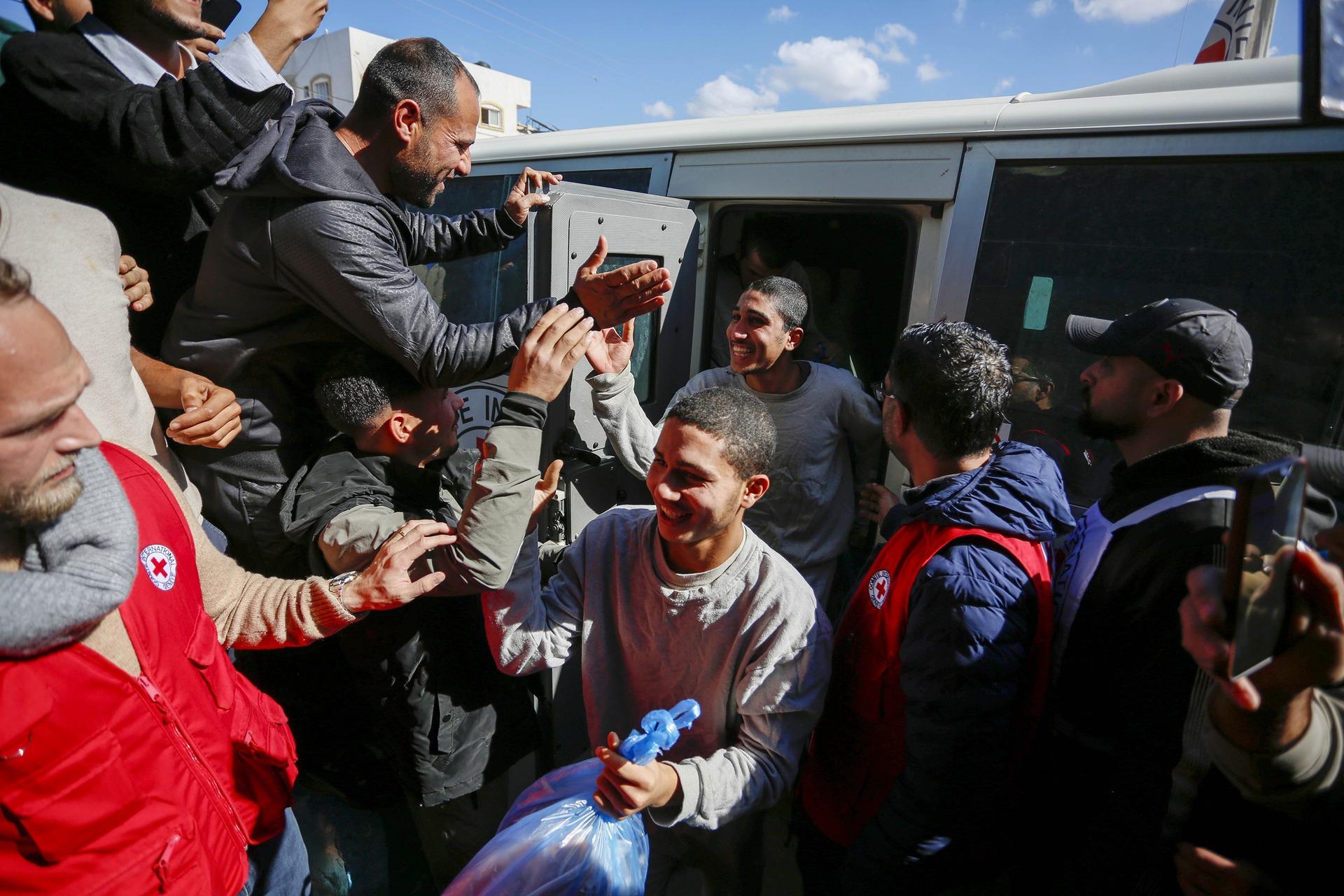 Palestinian prisoners emerge from a Red Cross vehicle as they are greeted by a large crowd at an exchange facilitated by the Red Cross in Deir al-Balah, Gaza. February 4, 2026.