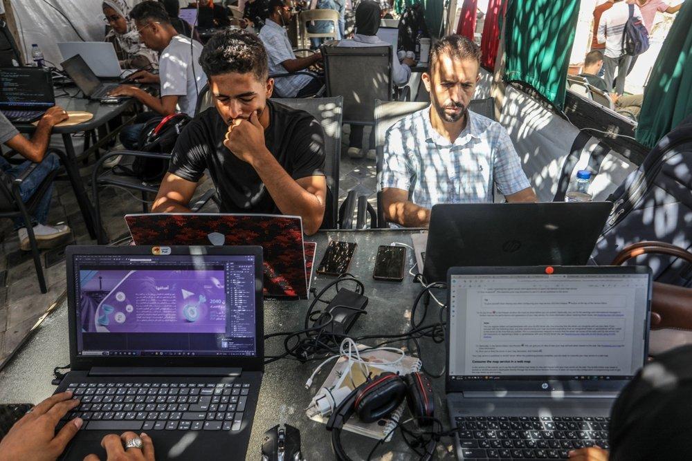 Palestinians work on their laptops at a cafe which offers internet access, which has become difficult to obtain, in the southern Gaza Strip city of Rafah. July 19, 2024.