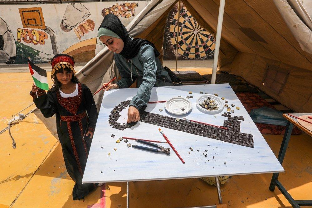 Palestinians commemorate the 75th anniversary of the Nakba in Khan Yunis as they create a large piece of tiled art symbolizing the right of return key. May 2023.
