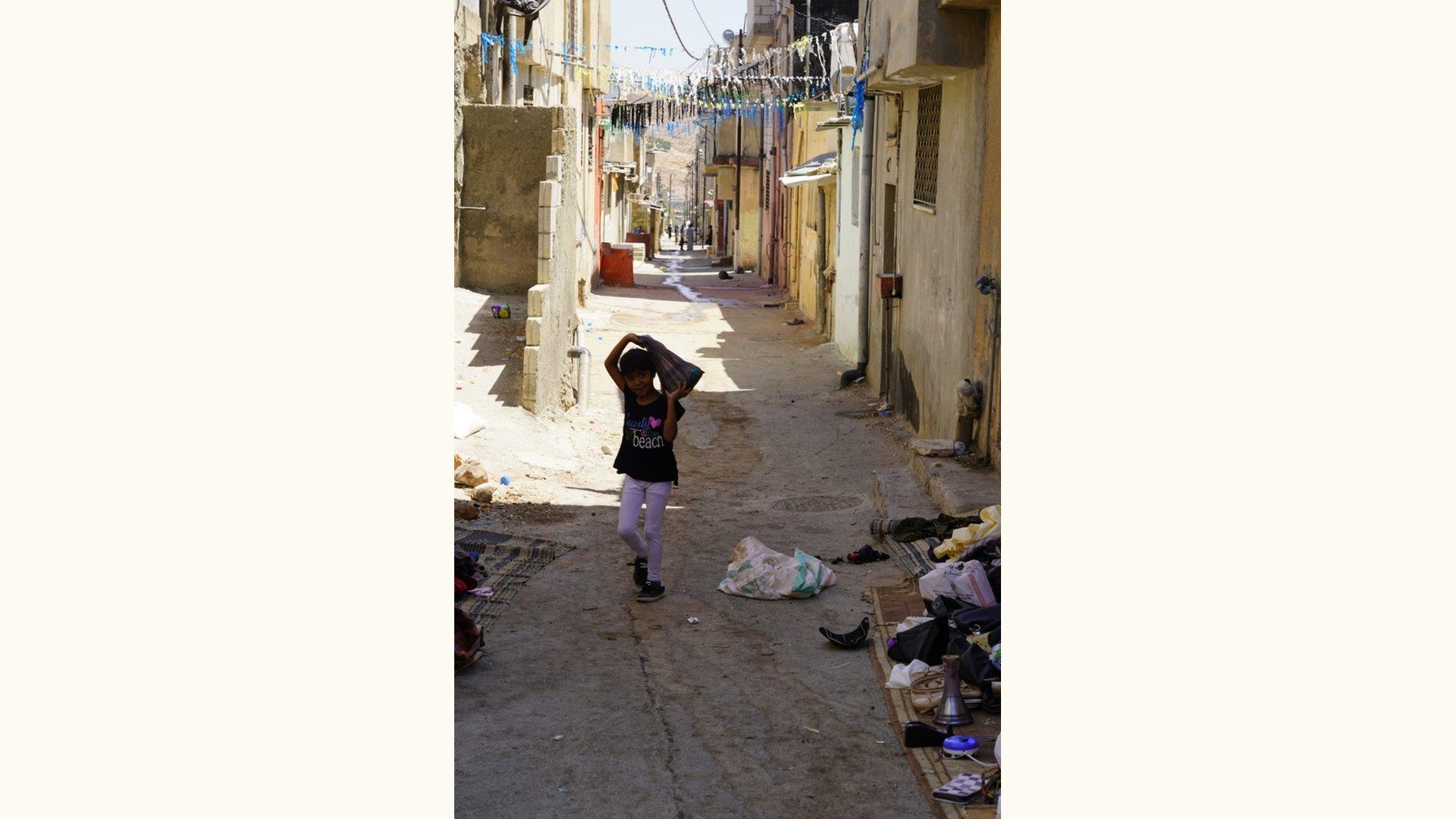 A young girl walks down the street in an UNRWA refugee camp in Jerash, Jordan.