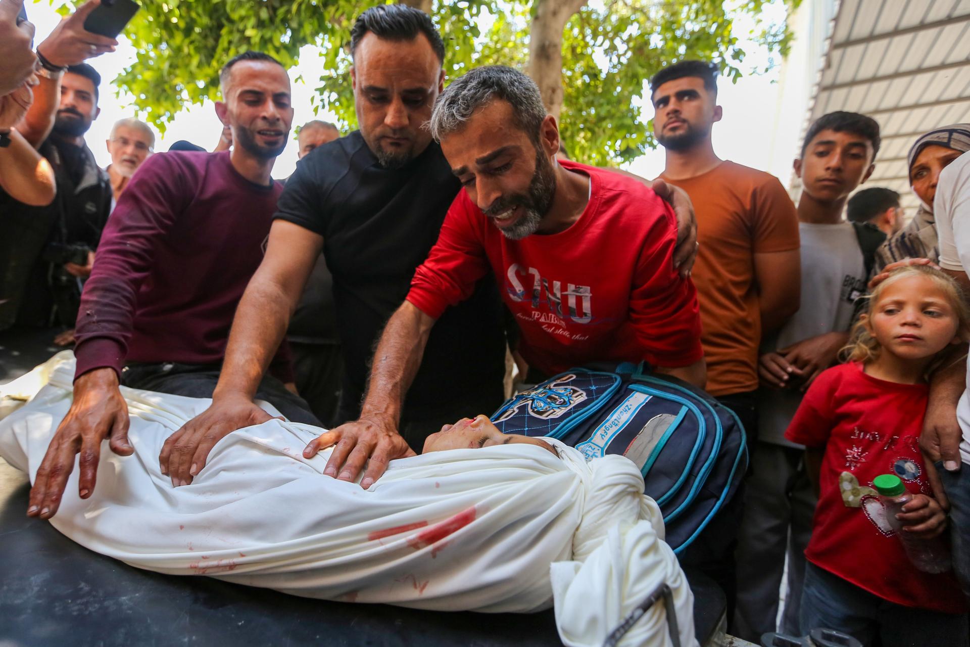 Jad Suleiman, a Palestinian father, bids farewell to his 8-year-old son as he is surrounded by other mourners. His child was killed in an Israeli airstrike on Jabaliya near Gaza City on June 8, 2026.