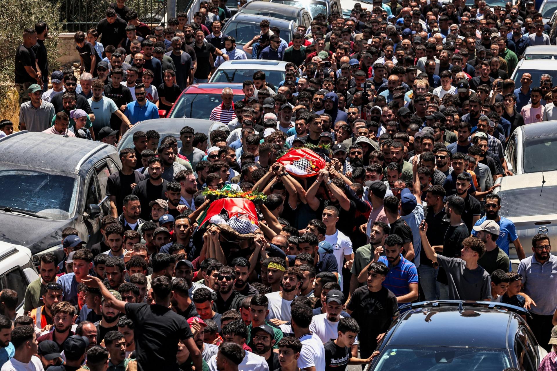 Mourners carry the bodies of dual US-Palestinian citizen Saif al-Din Kamil Abdul Karim Musalat and Palestinian Mohammad al-Shalabi during their funeral at the Palestinian village of Al-Mazraa Al-Sharqiya in the occupied West Bank on July 13, 2025, after they were reportedly killed by Israeli settlers two days prior. 