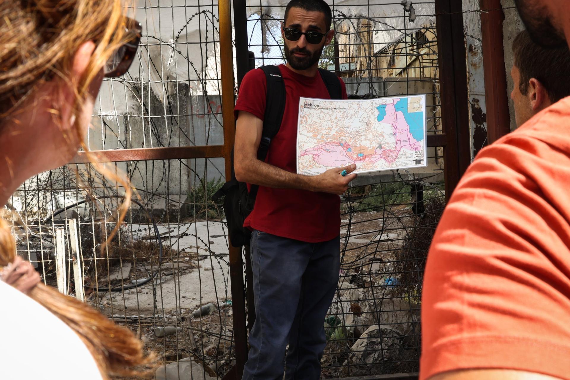 A tour guide shows a map of the restrictions on Palestinian movement in Hebron during a city tour for European citizens on July 18, 2022 in Hebron, West Bank.