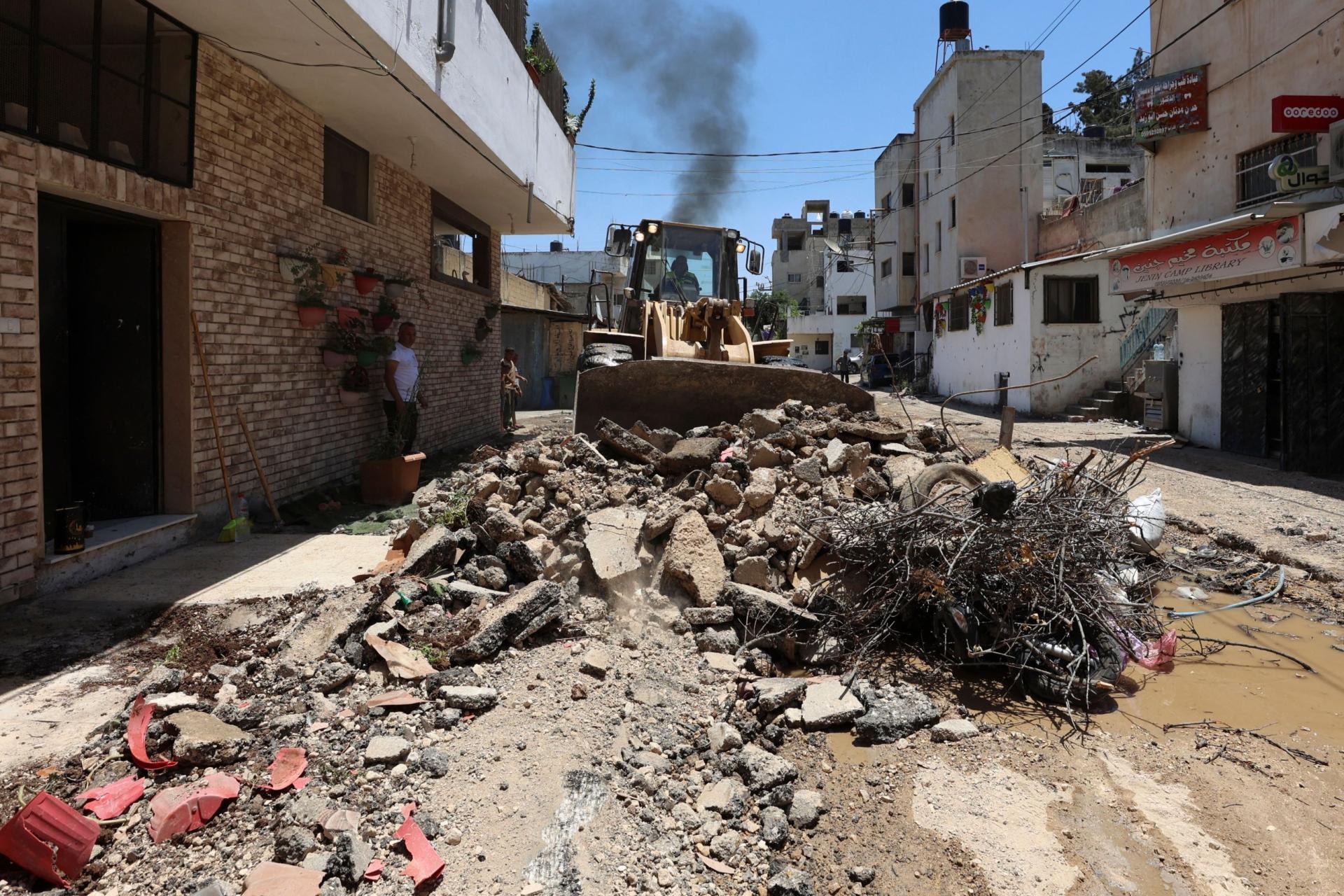 A bulldozer clears the rubble along a street in the occupied West Bank Jenin refugee camp on July 6, 2023, following a large-scale Israeli military operation that lasted for two days. The Israeli military launched the raid on the Jenin refugee camp early on July 3, during which 12 Palestinians and one Israeli soldier were killed.