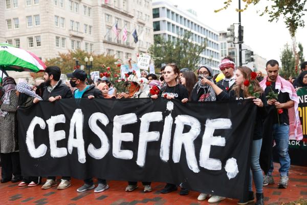 Protestors against Israel's genocide in Gaza carry a banner that says "CEASEFIRE."