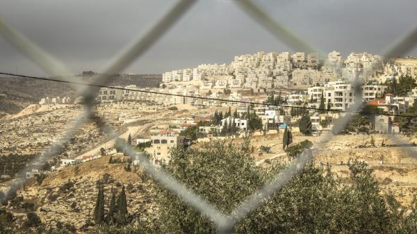 Image behind a fence showing the Israeli settlement of Har Homa in southern East Jerusalem, built on land seized from the Palestinian villages of Umm Tuba and Beit Sahour.