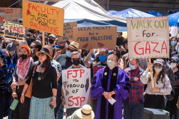 University faculty protest ifor a ceasefire in Gaza and in solidarity with students. Signs say "Faculty for Justice in Palestine," "UCLA Faculty for a Free Palestine," "Walk out for Gaza," and "FJP is proud of SJP."