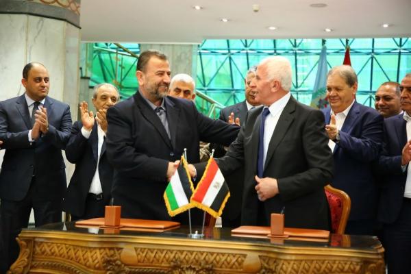 Hamas leader Saleh Al-Arouri and Fatah leader Azzam Ahmad shake hands after the signing of a national reconciliation agreement in Cairo. They are joined by other leaders from the respective factions, including Yahya Sinwar and Hussein Al-Sheikh, and chief of the Egyptian General Intelligence Directorate Khaled Fawzy.