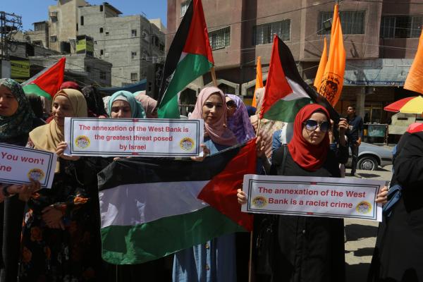 Palestinian women in the Gaza Strip  protest against West Bank and Jordan Valley annexation. They carry Palestinian flags and signs that say: "the annexation of the West Bank is a racist crime," and "the annexation of the West Bank is the greatest threat posed by Israel."