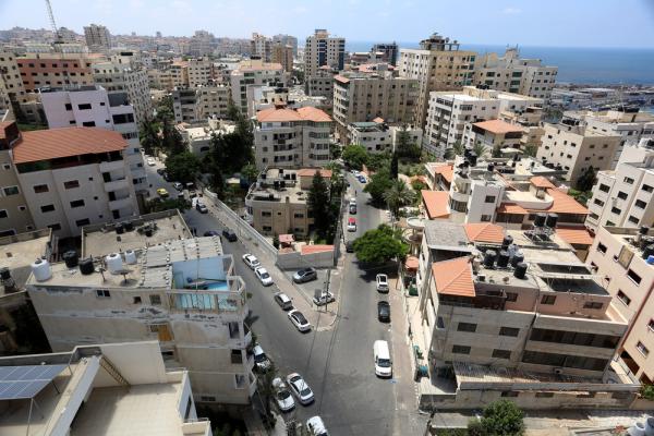 Aerial view of Gaza City's high-rise and multi-story residential buildings with the Mediterranean Sea visible in the background.