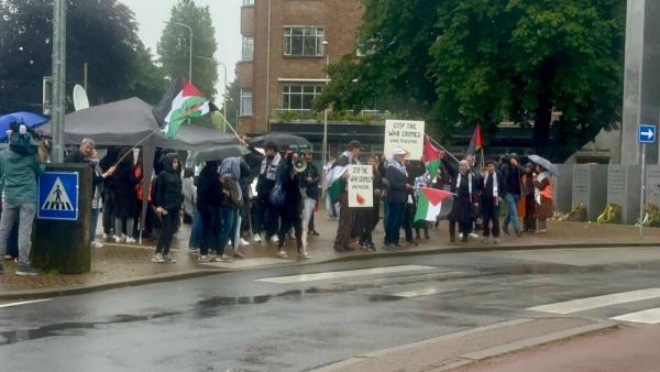 Rally near the International Court of Justice (ICJ) in the Hague, Netherlands, carrying posters that read "STOP THE WAR CRIMES, SAVE PALESTINE" and Palestinian flags.