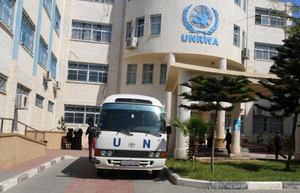 Exterior view of an UNRWA facility, with a United Nations (UN) van parked outside of the building.