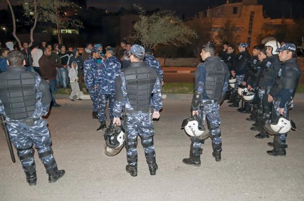 Members of Palestinian National Security Forces equipped with riot gear block off a street during a protest in Bethlehem.