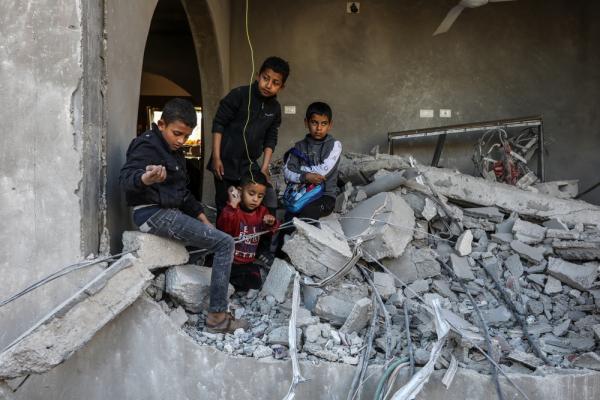 Palestinian children stand on the rubble of their home in Khan Yunis, Gaza.