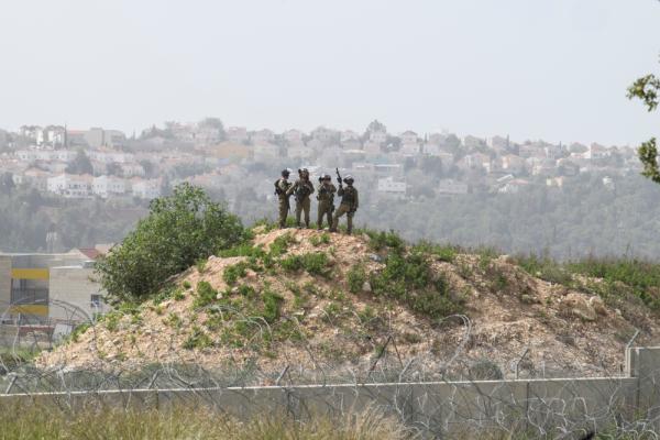 Israeli soldiers stand atop a hill overlooking a protest in Bil`in, a village in the West Bank.