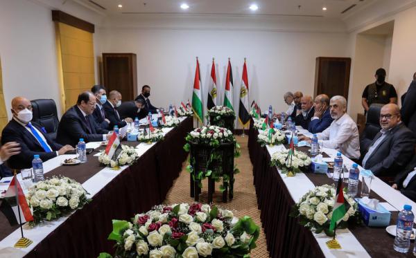 Hamas Political Bureau leaders meet with Egyptian Intelligence director Major General Abbas Kamel and other Egyptian General Intelligence Service (GIS) officials in Gaza City. They are seated at two long conference tables with many Palestinian and Egyptian flags. Among those pictured include Essam al-Dalis, Yahya Sinwar, Khalil Al-Hayya, Major General Abbas Kamel, and GIS Chief of Palestinian Affairs Ahmed Abdel Khalek. May 2021.