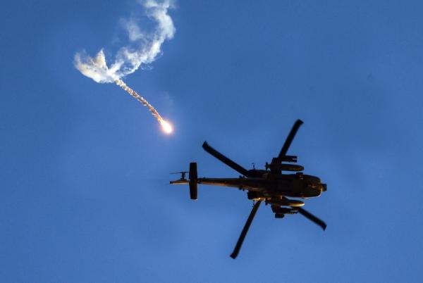 View of an Israeli Apache helicopter flying overhead as it releases a flare over Gaza.