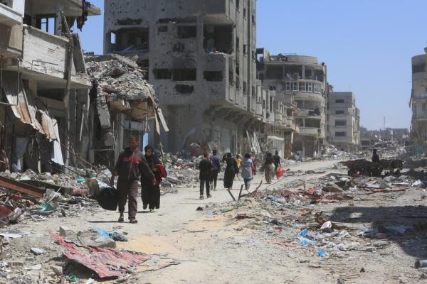 Palestinians walk amid the ruins and large-scale destruction in Khan Yunis caused by Israel's genocide. April 2024.