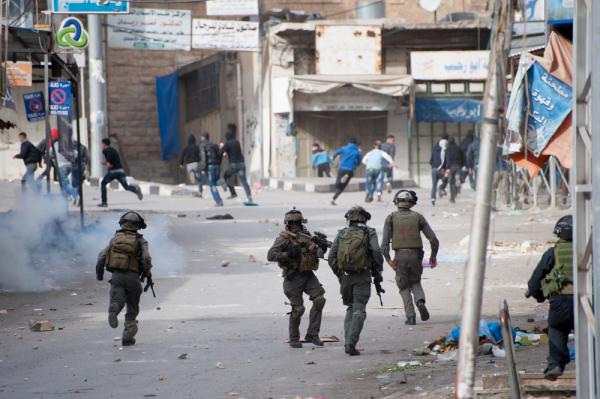 Israeli soldiers chase Palestinians during a protest against the occupation in Hebron.