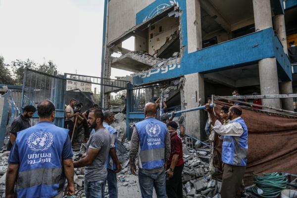 UNRWA staff inspect the damage inflicted on the Nuseirat Refugee Camp in the Gaza Strip following an Israeli airstrike, July 2024.