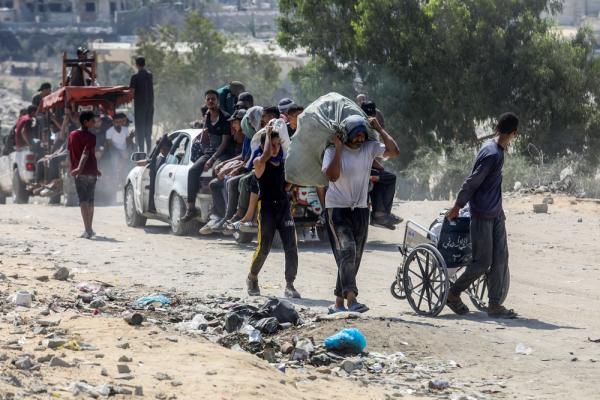 Palestinians stand amid the rubble in Gaza after the January 2025 Gaza ceasefire.