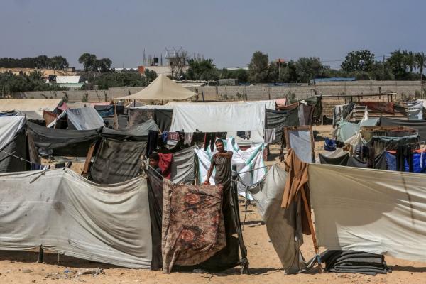A displaced Palestinian walks between the crowded tents in the central Gaza Strip town of Deir al-Balah.