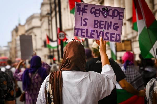 Sign at a protest in London, UK reads "the genocide is being televised."