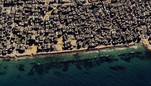 Aerial view of Gaza Strip destruction along the Mediterranean sea coastline, showing rubble, destroyed buildings, and destroyed roads.