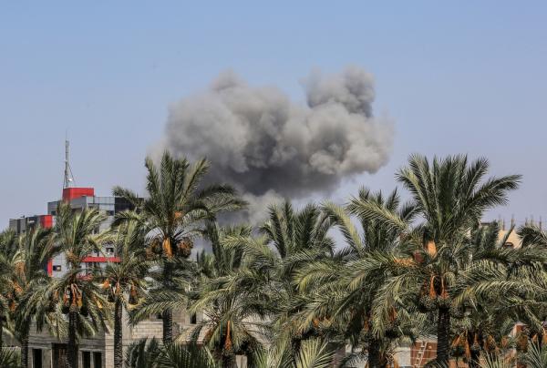 Smoke rises over date palm trees in Deir al-Balah, in the central Gaza Strip, a town known for its date trees and agricultural sites.