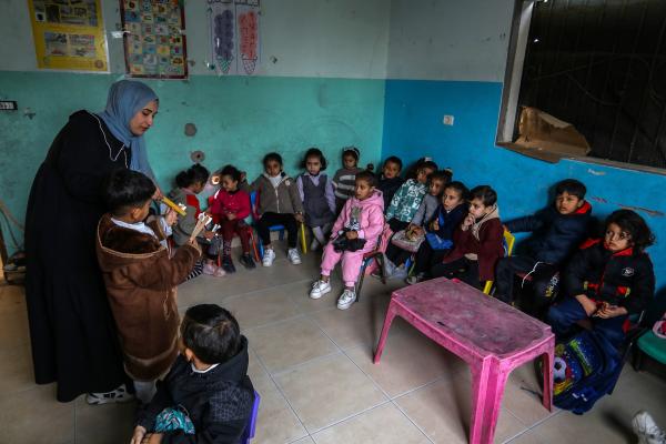In a paritally destroyed kindergarten classroom, a teacher gives a lesson to her students. January 28, 2026.