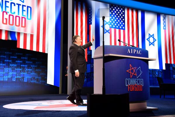 US Secretary of State Mike Pompeo approaches the podium at the 2019 AIPAC Policy Conference, on screen are Israeli and American flags with the slogan "connected for good."